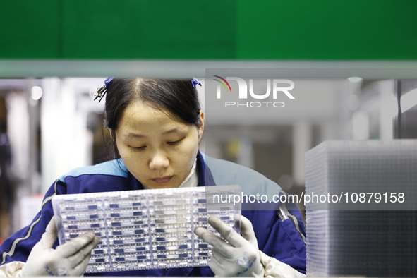 A worker is working on the production line of an electronic components company in Suqian, Jiangsu Province, China, on December 29, 2023. 