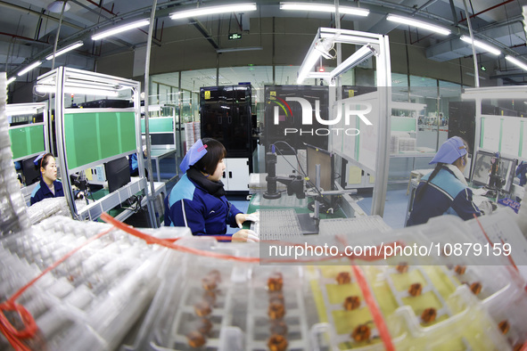 A worker is working on the production line of an electronic components company in Suqian, Jiangsu Province, China, on December 29, 2023. 