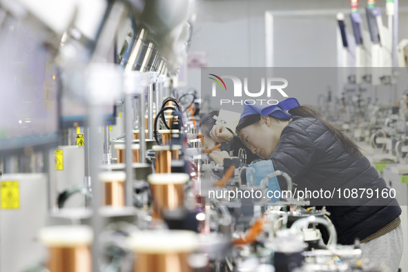 A worker is working on the production line of an electronic components company in Suqian, Jiangsu Province, China, on December 29, 2023. 