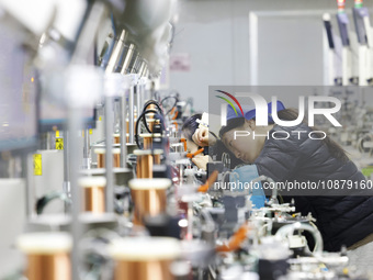 A worker is working on the production line of an electronic components company in Suqian, Jiangsu Province, China, on December 29, 2023. (