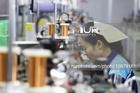 A worker is working on the production line of an electronic components company in Suqian, Jiangsu Province, China, on December 29, 2023. 