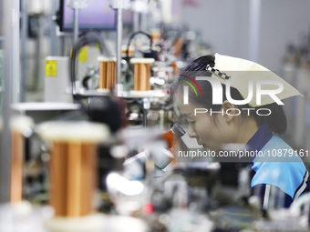 A worker is working on the production line of an electronic components company in Suqian, Jiangsu Province, China, on December 29, 2023. (