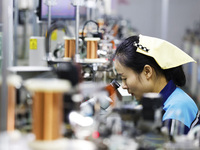 A worker is working on the production line of an electronic components company in Suqian, Jiangsu Province, China, on December 29, 2023. (