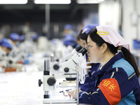 Workers are working on the production line of an electronic components company in Suqian, Jiangsu province, China, on December 29, 2023. (