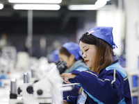 Workers are working on the production line of an electronic components company in Suqian, Jiangsu province, China, on December 29, 2023. (