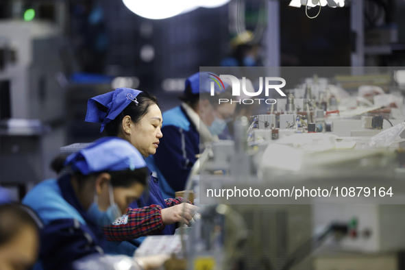 Workers are working on the production line of an electronic components company in Suqian, Jiangsu province, China, on December 29, 2023. 