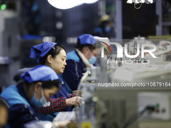 Workers are working on the production line of an electronic components company in Suqian, Jiangsu province, China, on December 29, 2023. (