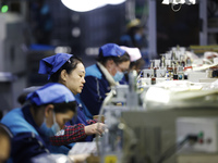 Workers are working on the production line of an electronic components company in Suqian, Jiangsu province, China, on December 29, 2023. (