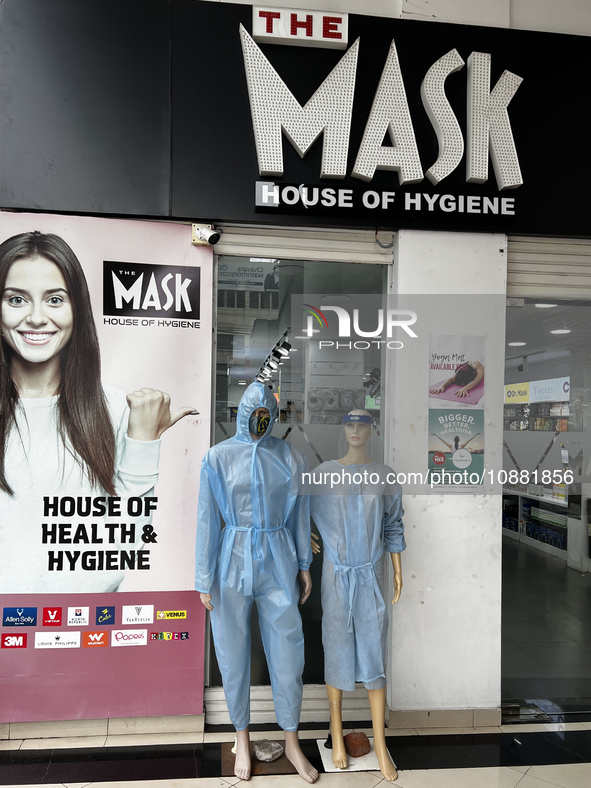 Mannequins are standing outside a shop that is selling face masks, hand sanitizer, and other personal protective equipment to help protect a...