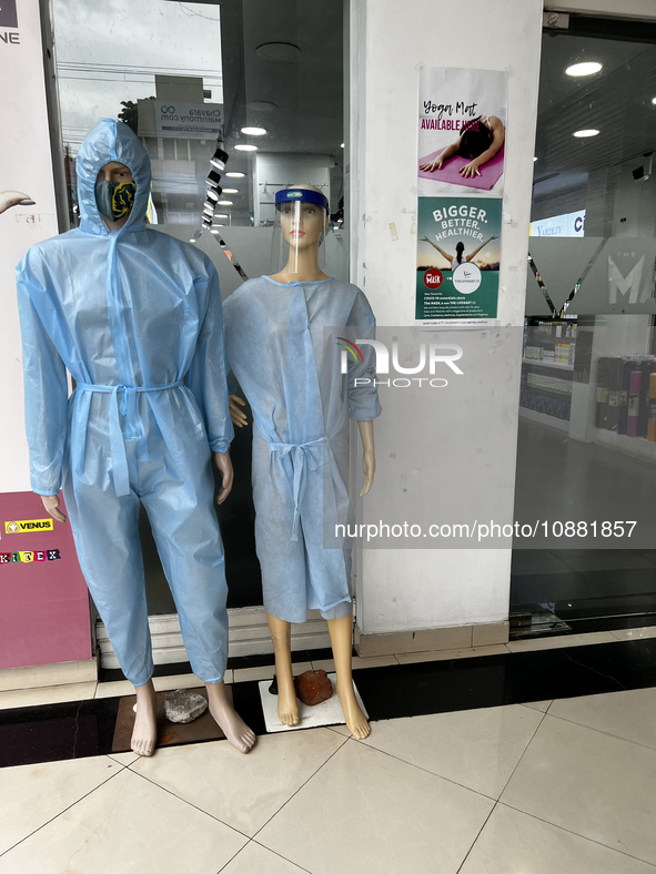 Mannequins are standing outside a shop that is selling face masks, hand sanitizer, and other personal protective equipment to help protect a...