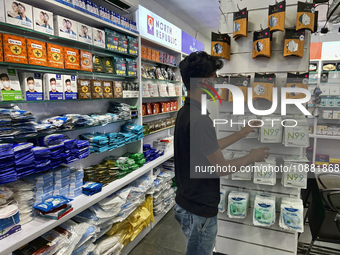 A man is purchasing N99 face masks at a shop that sells face masks, hand sanitizer, and other personal protective equipment to help protect...