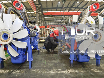 A worker is assembling a generator at a manufacturing enterprise in Qingzhou, East China's Shandong province, on December 31, 2023. (