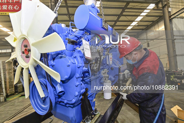 A worker is assembling a generator at a manufacturing enterprise in Qingzhou, East China's Shandong province, on December 31, 2023. 