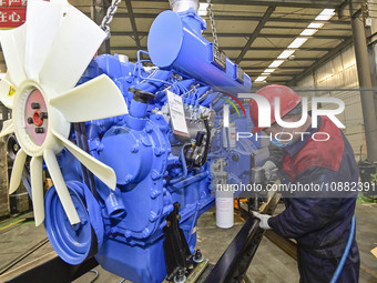 A worker is assembling a generator at a manufacturing enterprise in Qingzhou, East China's Shandong province, on December 31, 2023. (