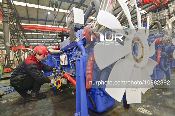 A worker is assembling a generator at a manufacturing enterprise in Qingzhou, East China's Shandong province, on December 31, 2023. 