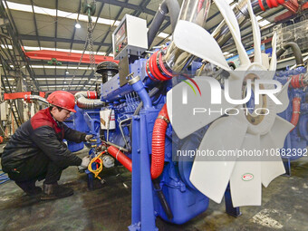 A worker is assembling a generator at a manufacturing enterprise in Qingzhou, East China's Shandong province, on December 31, 2023. (