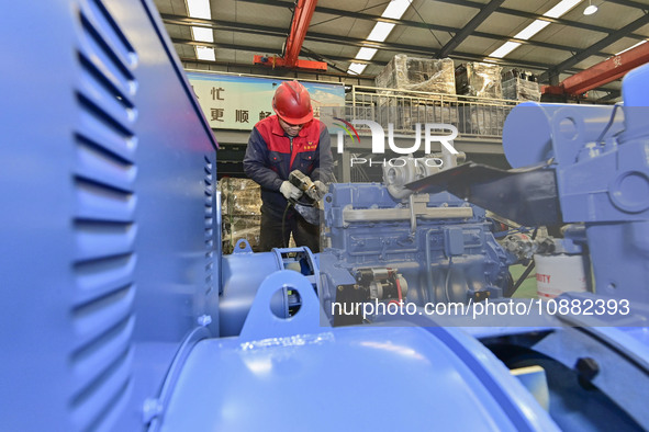 A worker is assembling a generator at a manufacturing enterprise in Qingzhou, East China's Shandong province, on December 31, 2023. 