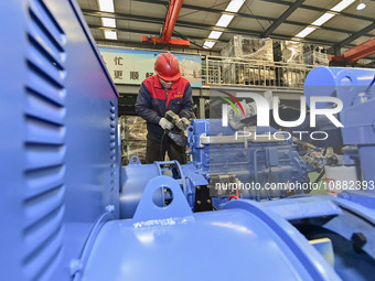 A worker is assembling a generator at a manufacturing enterprise in Qingzhou, East China's Shandong province, on December 31, 2023. (