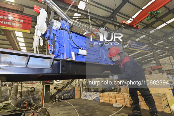 A worker is assembling a generator at a manufacturing enterprise in Qingzhou, East China's Shandong province, on December 31, 2023. 