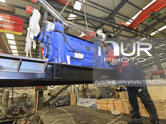 A worker is assembling a generator at a manufacturing enterprise in Qingzhou, East China's Shandong province, on December 31, 2023. (