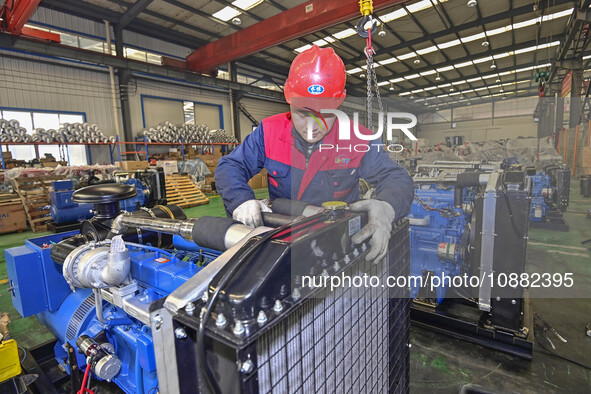 A worker is assembling a generator at a manufacturing enterprise in Qingzhou, East China's Shandong province, on December 31, 2023. 