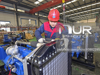 A worker is assembling a generator at a manufacturing enterprise in Qingzhou, East China's Shandong province, on December 31, 2023. (