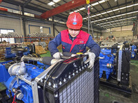 A worker is assembling a generator at a manufacturing enterprise in Qingzhou, East China's Shandong province, on December 31, 2023. (