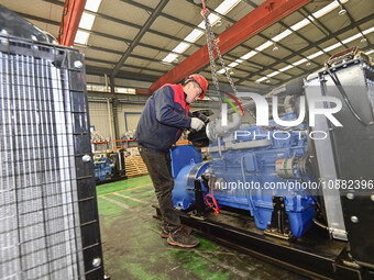 A worker is assembling a generator at a manufacturing enterprise in Qingzhou, East China's Shandong province, on December 31, 2023. (