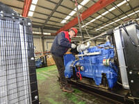 A worker is assembling a generator at a manufacturing enterprise in Qingzhou, East China's Shandong province, on December 31, 2023. (