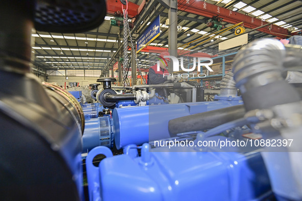 A worker is assembling a generator at a manufacturing enterprise in Qingzhou, East China's Shandong province, on December 31, 2023. 