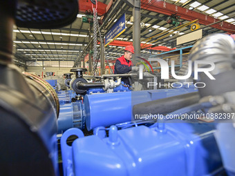 A worker is assembling a generator at a manufacturing enterprise in Qingzhou, East China's Shandong province, on December 31, 2023. (