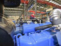 A worker is assembling a generator at a manufacturing enterprise in Qingzhou, East China's Shandong province, on December 31, 2023. (