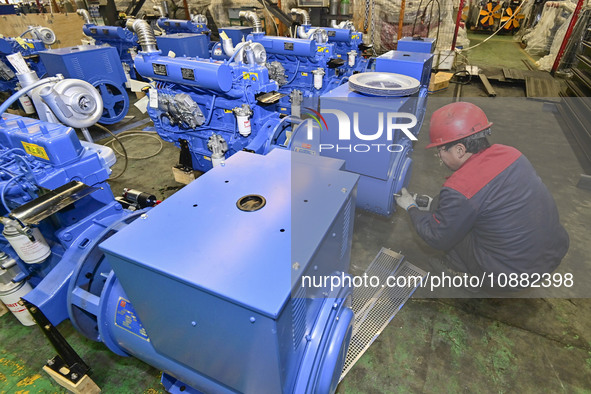 A worker is assembling a generator at a manufacturing enterprise in Qingzhou, East China's Shandong province, on December 31, 2023. 