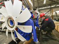 A worker is assembling a generator at a manufacturing enterprise in Qingzhou, East China's Shandong province, on December 31, 2023. (