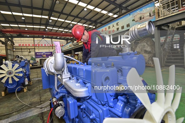 A worker is assembling a generator at a manufacturing enterprise in Qingzhou, East China's Shandong province, on December 31, 2023. 