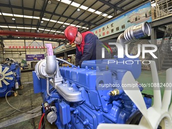 A worker is assembling a generator at a manufacturing enterprise in Qingzhou, East China's Shandong province, on December 31, 2023. (