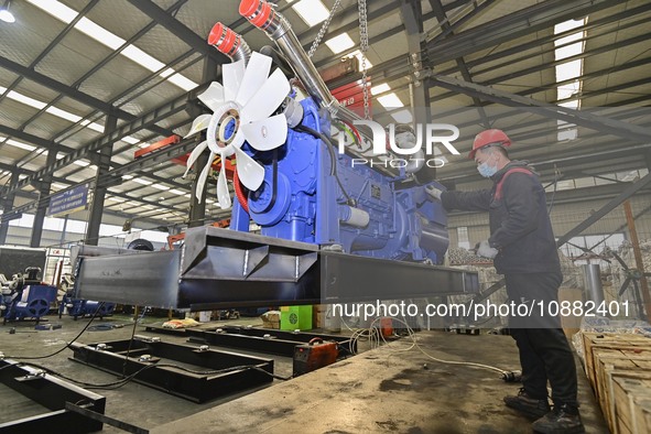 A worker is assembling a generator at a manufacturing enterprise in Qingzhou, East China's Shandong province, on December 31, 2023. 