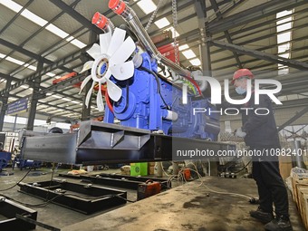 A worker is assembling a generator at a manufacturing enterprise in Qingzhou, East China's Shandong province, on December 31, 2023. (