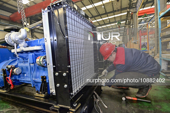 A worker is assembling a generator at a manufacturing enterprise in Qingzhou, East China's Shandong province, on December 31, 2023. 