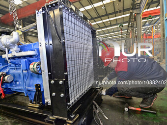 A worker is assembling a generator at a manufacturing enterprise in Qingzhou, East China's Shandong province, on December 31, 2023. (