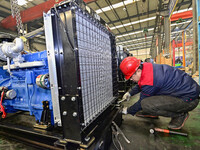 A worker is assembling a generator at a manufacturing enterprise in Qingzhou, East China's Shandong province, on December 31, 2023. (