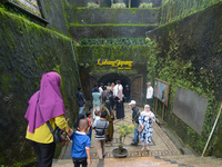 People are standing near the entrance of Lobang Jepang (Japanese tunnel), a historical tourist attraction in Bukittinggi, West Sumatra, Indo...