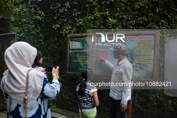 A guide is accompanying tourists as they visit the Japanese tunnel, also known as Lobang Jepang, at the historical tourist attraction in Buk...