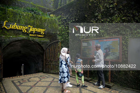 A guide is accompanying tourists as they visit the Japanese tunnel, also known as Lobang Jepang, at the historical tourist attraction in Buk...