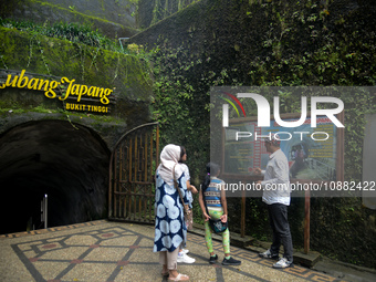 A guide is accompanying tourists as they visit the Japanese tunnel, also known as Lobang Jepang, at the historical tourist attraction in Buk...