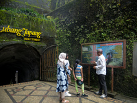 A guide is accompanying tourists as they visit the Japanese tunnel, also known as Lobang Jepang, at the historical tourist attraction in Buk...