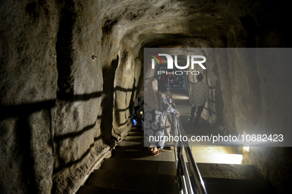 Visitors are walking through the Lobang Jepang (Japanese Tunnel), a historical tourist attraction in Bukittinggi, West Sumatra, Indonesia, o...