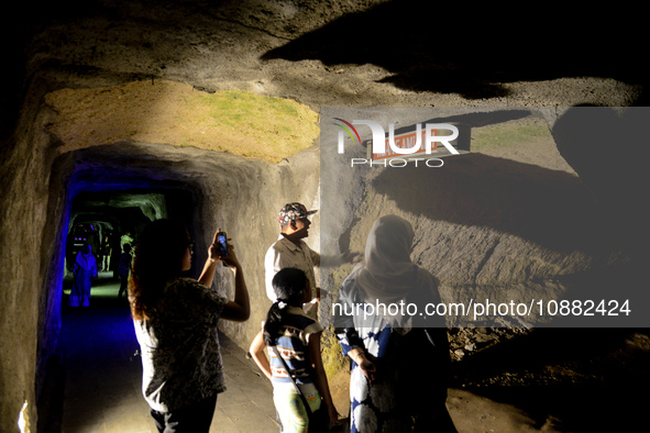 A guide is accompanying tourists as they visit the Japanese tunnel, also known as Lobang Jepang, at the historical tourist attraction in Buk...