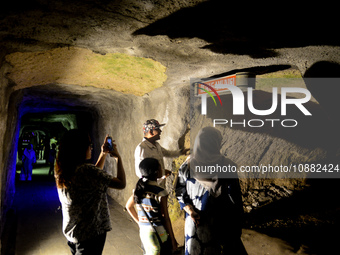 A guide is accompanying tourists as they visit the Japanese tunnel, also known as Lobang Jepang, at the historical tourist attraction in Buk...