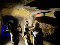 A guide is accompanying tourists as they visit the Japanese tunnel, also known as Lobang Jepang, at the historical tourist attraction in Buk...